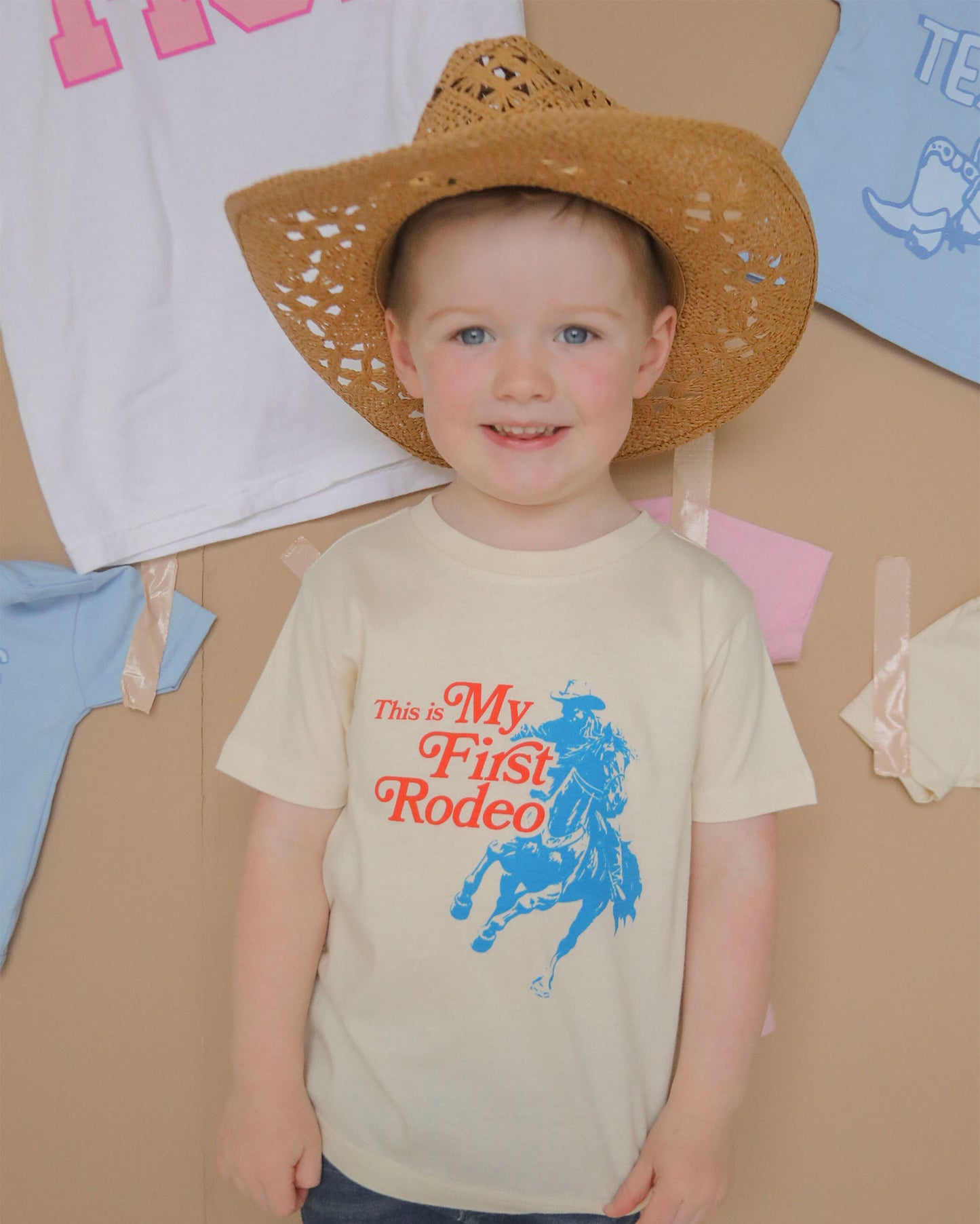 Adorable toddler wearing the 'Not My First Rodeo Tee' by Charlie Southern, showcasing a playful cowboy graphic and bright colors, perfect for little cowboys and cowgirls.