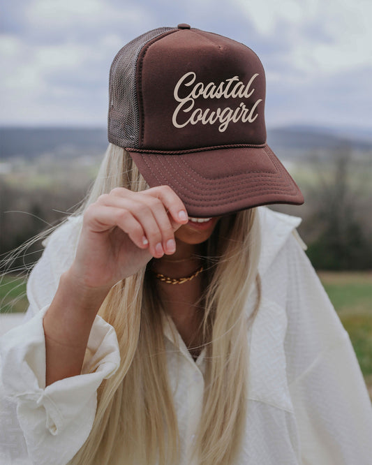 Woman wearing Women's Coastal Cowgirl Trucker Cap by Charlie Southern, showcasing the stylish chocolate brown hat with tan embroidery, perfect for coastal adventures.